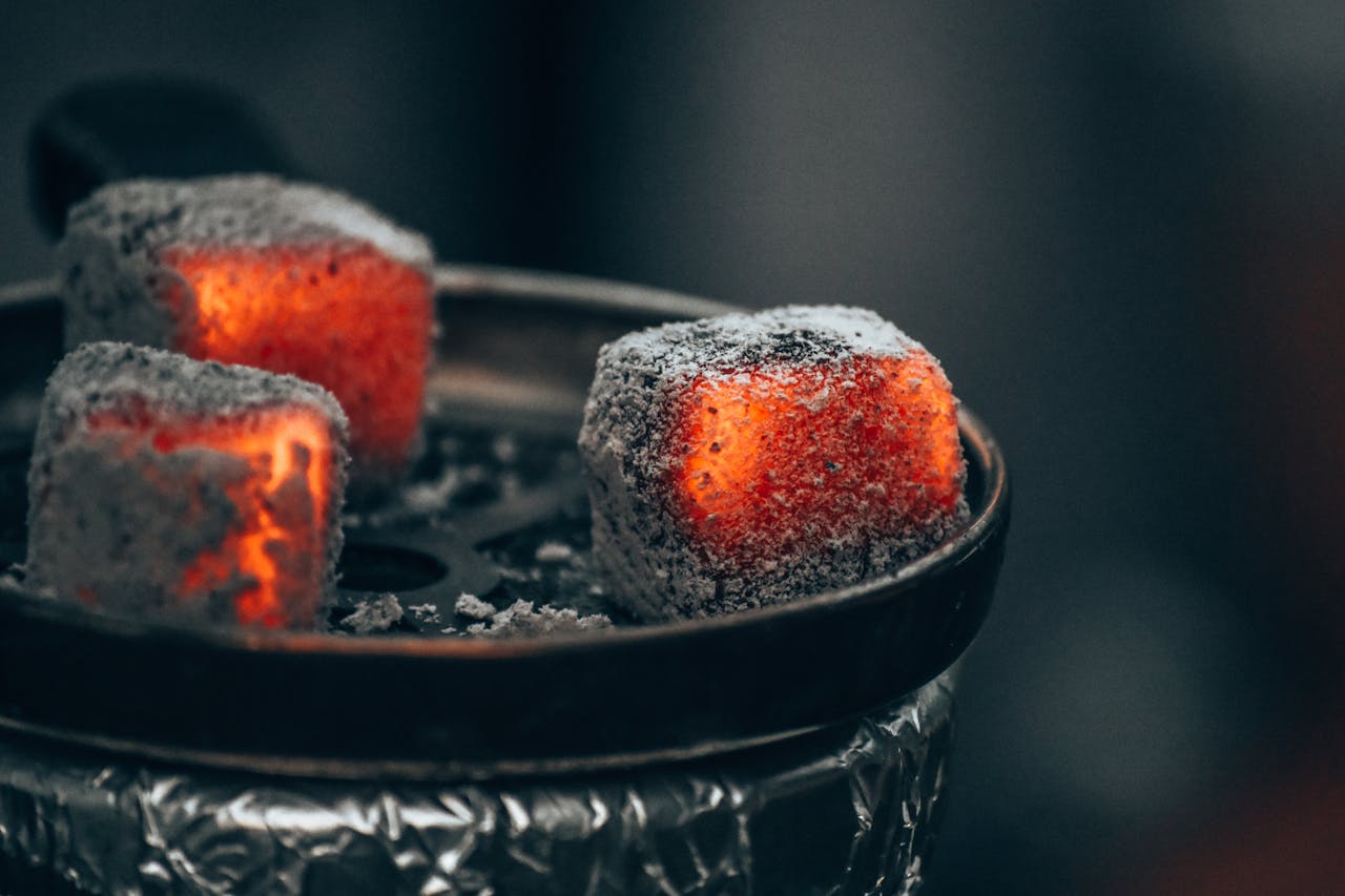 Crafting Captivating Headlines: Your awesome post title goes here A close-up view of glowing charcoal cubes on a metal plate, used for hookah in Stuttgart, Germany.